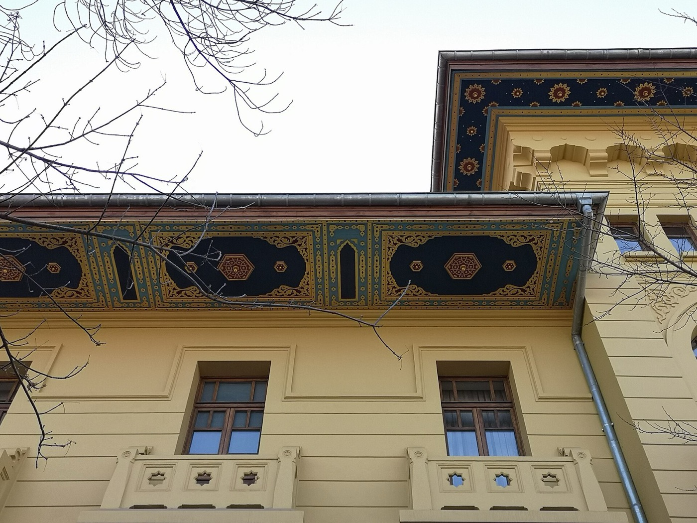 The deep eaves of Ankara Palas, painted with dark medallion panels, above the balconied upper-floor windows