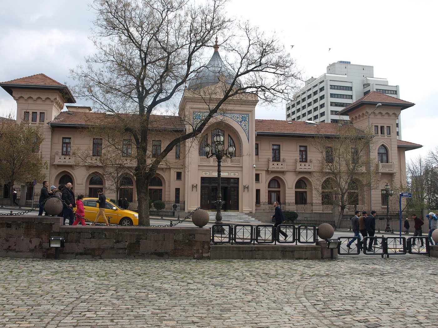The front of Ankara Palas with its tiled central entrance bay and corner towers, seen across the cobbled forecourt of the Second Parliament building