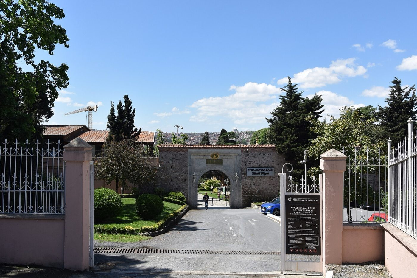 The street entrance to Aynalıkavak Pavilion: an iron gate, a sign board and, beyond a short drive, an arched stone gateway with the name of the pavilion