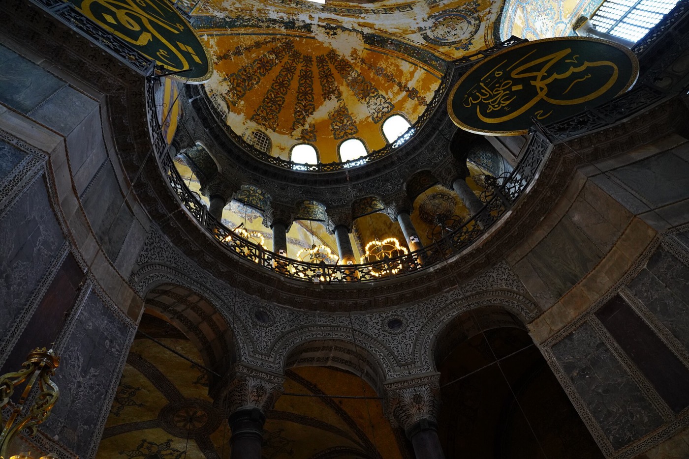 A semi-dome and the gallery colonnade of Hagia Sophia, with two of the calligraphic roundels