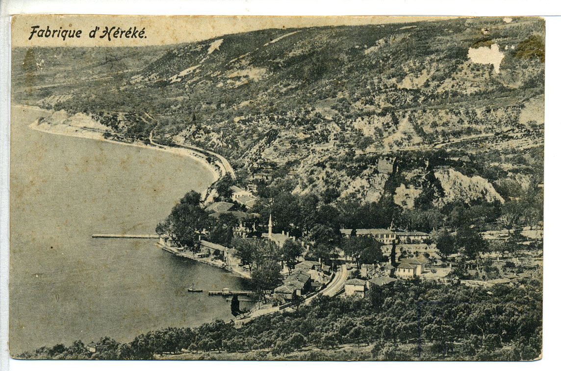 A postcard from before 1915 titled “Fabrique d’Héréké”, showing the factory buildings and jetties along the shore below wooded hills
