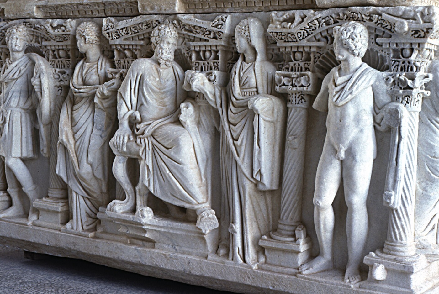 Reliefierte Figuren an der Seite eines Sarkophags im Museum