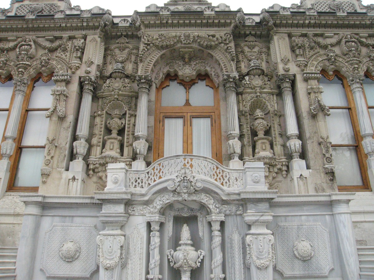 Close view of the Ceremonial Pavilion's marble front at Ihlamur: carved columns, niches holding stone urns, a small balcony and the fountain niche below it