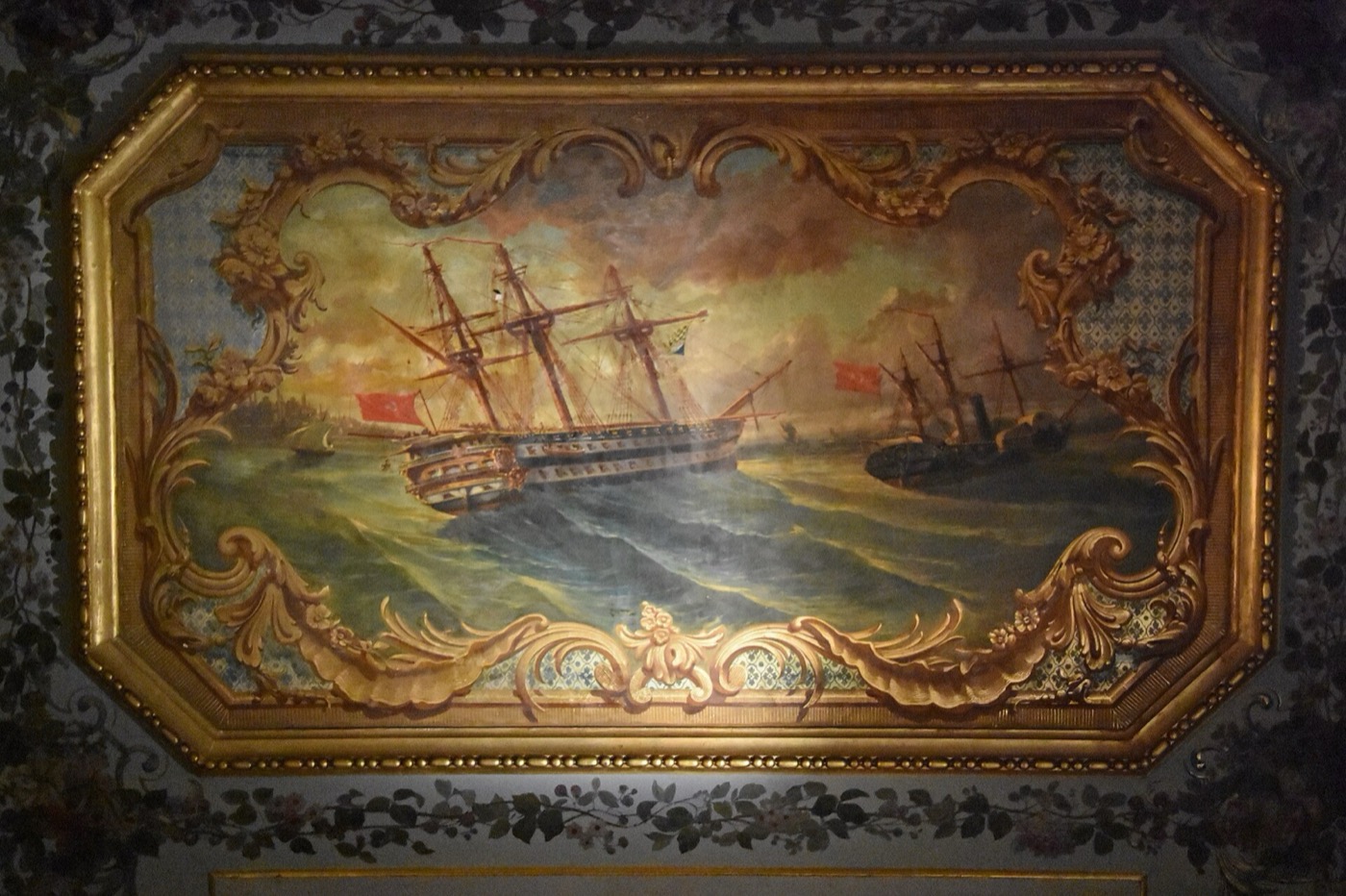 A ceiling panel in the Crown Prince's Apartment: a painting of two sailing warships on a rough sea, one flying a red flag, in a gilded rocaille frame
