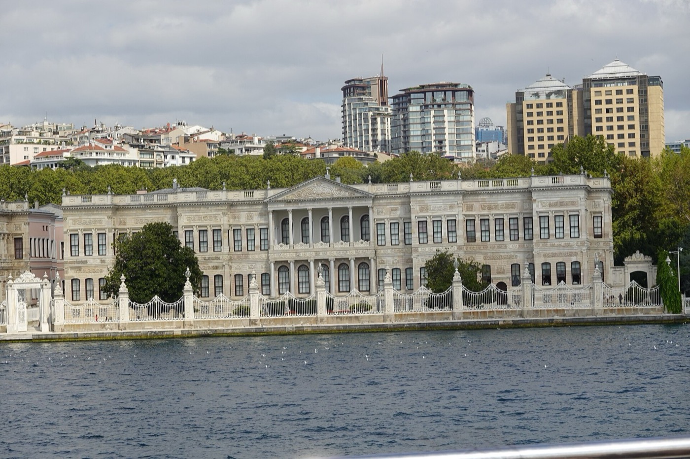 The Bosphorus façade of the Crown Prince's Apartment at Dolmabahçe, which houses the Painting Museum: white stone with a columned centre under a pediment, behind the palace's iron sea railings