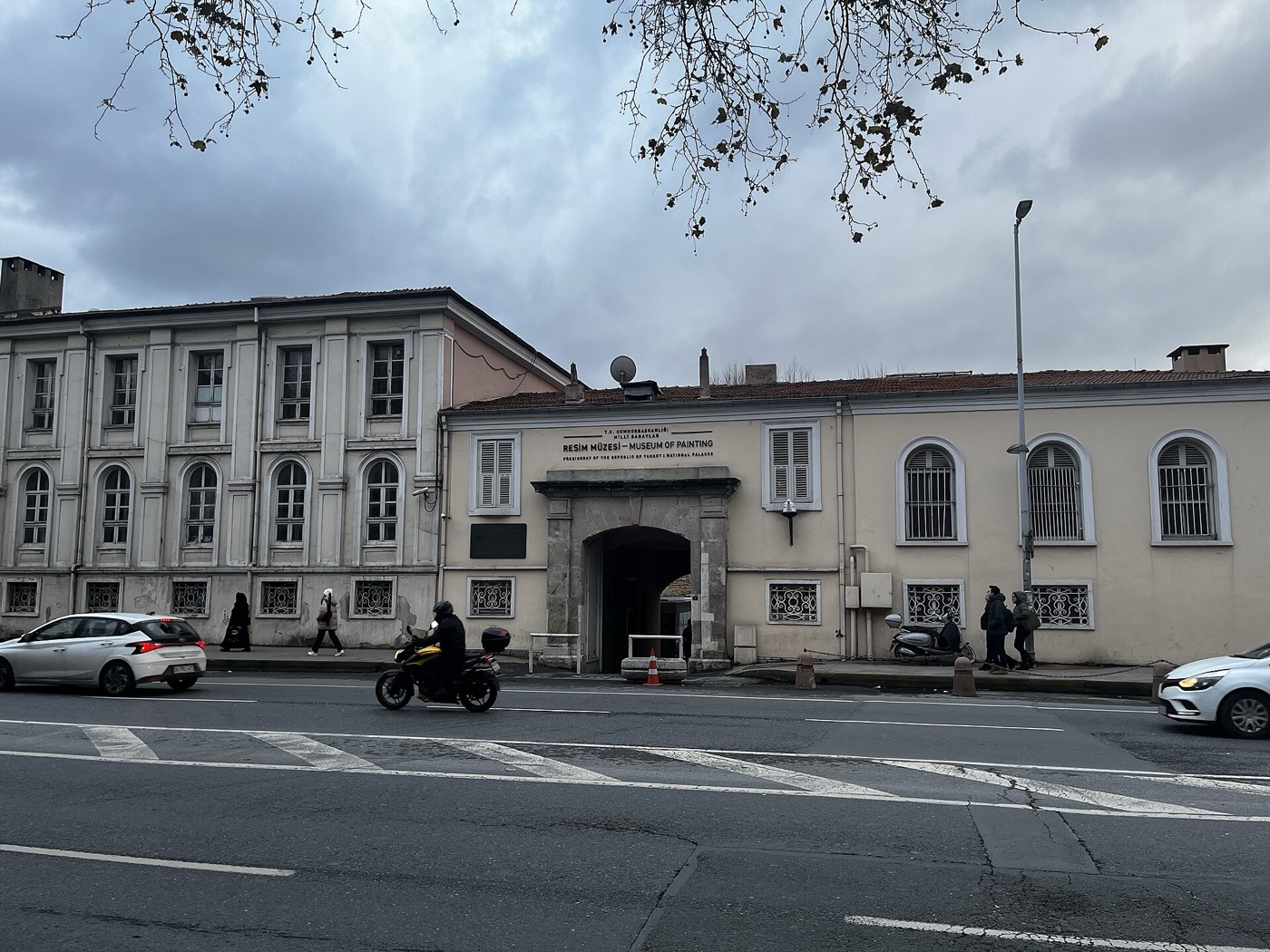 A stone gateway on Dolmabahçe Caddesi with the sign "Resim Müzesi - Museum of Painting" above it, set in a low cream-coloured building, with traffic passing in front