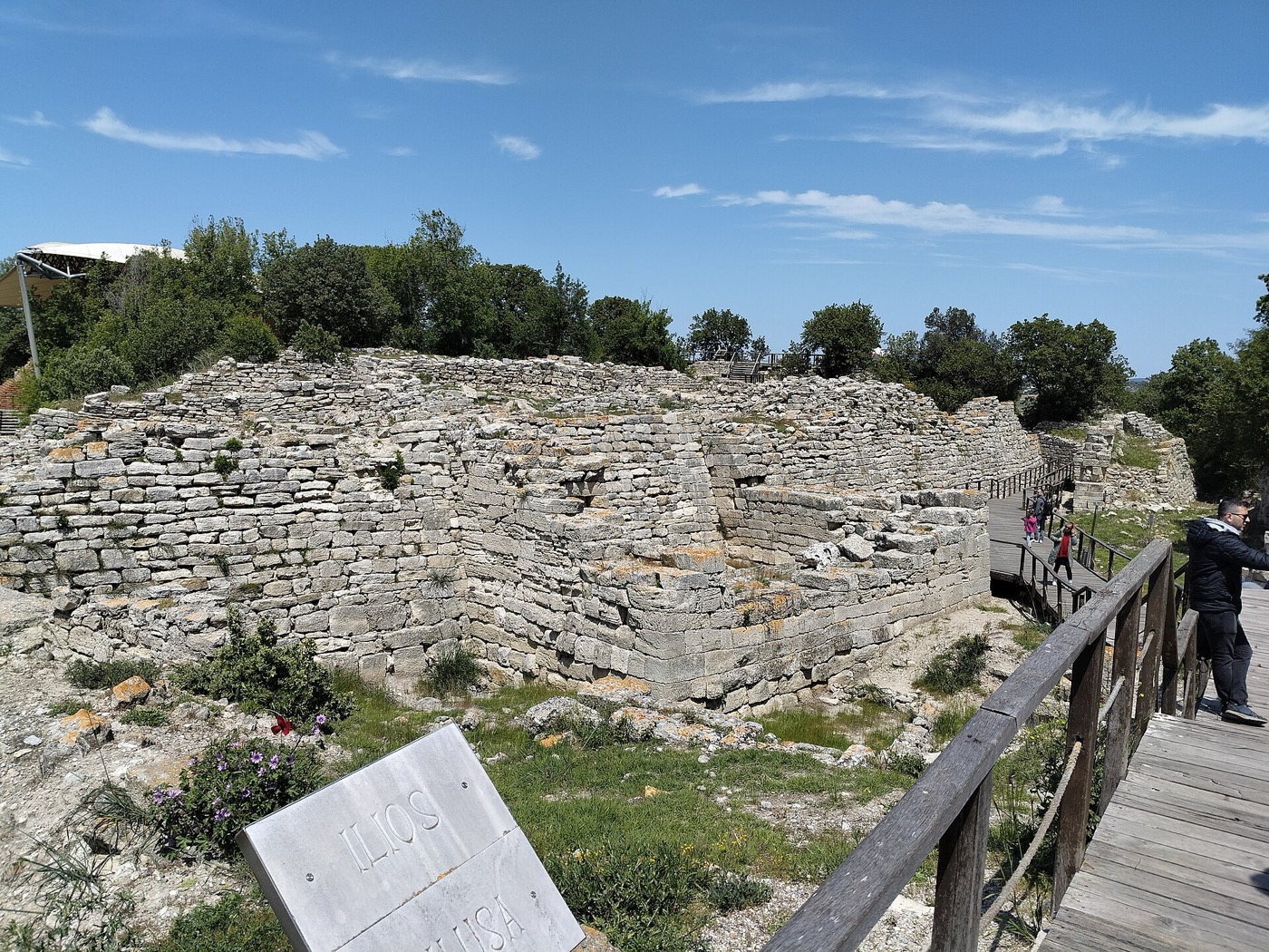 Visitors on the walkway beside a stretch of the Troy fortification wall